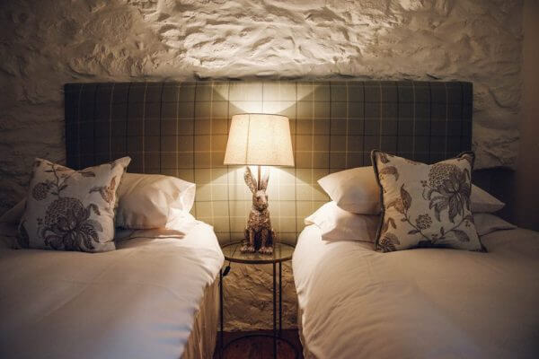 Twin beds with a bedside table and lamp between them